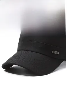 Detail of a black cotton twill flat top hat featuring a fashion metal side emblem