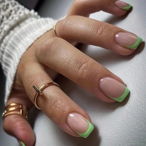 Close-up of elegant green French tip press-on nails featuring a clean minimalist design