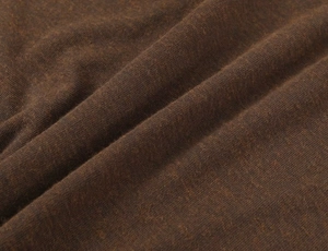 Macro view of dark brown knitted fabric texture showing premium material quality and soft folds