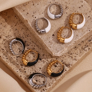 Detail view of pear-shaped twisted hoop earrings with black and white enamel on stone