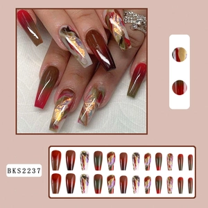 Detail of long coffin press-on nails with marble texture, gold foil, and color gradient