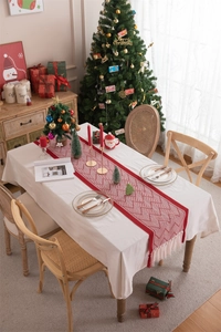 Detail of red and beige geometric jacquard table runner with handmade fringe tassels