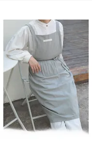 Close-up of light gray cotton apron fabric with H-shaped straps and breathable texture