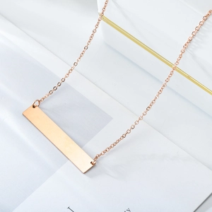 Minimalist rose gold stainless steel bar necklace on a white marble background
