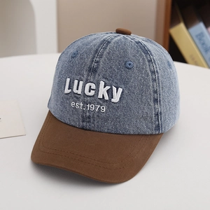 Detail of vintage denim cap showing 3D Lucky embroidery and brown suede brim texture