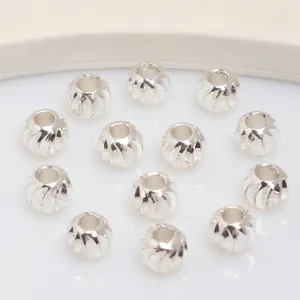 Detailed macro view of silver metallic spiral carved beads for DIY jewelry making