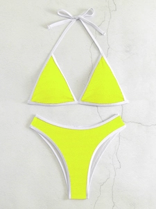 Detail des neon-gelben Bikinis mit strukturierter Textur und weißen Kontrastpaspeln