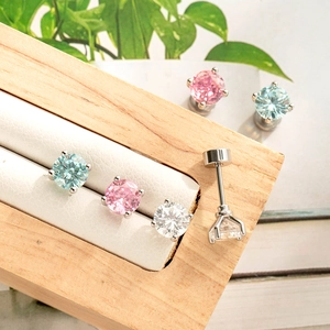 5mm silver cartilage studs with four-prong colorful zircons on a wooden jewelry stand