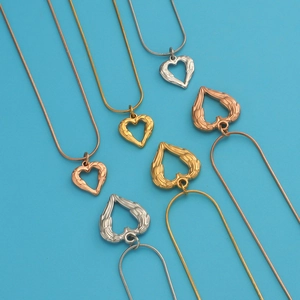 Multiple heart-shaped pendant necklaces with wing textures in gold, rose gold and silver