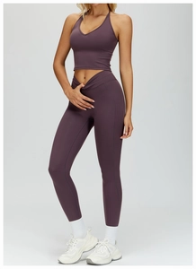 Detail of high-waisted yoga leggings with crossover waistband and dark purple v-neck top