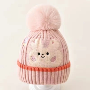 Pink knitted baby hat with fluffy pompom and cute bear embroidery for winter warmth