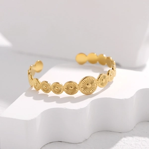 Detail of a gold open bangle with radiant sunburst pattern and geometric round links