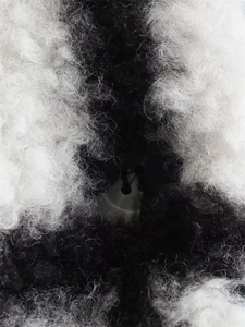 Macro shot of black and white plaid wool coat texture and dark button detail