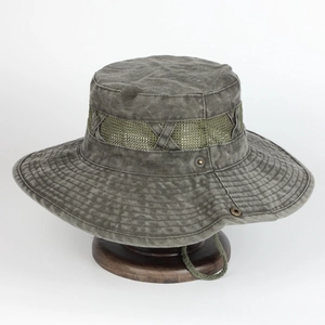 Detail of vintage sun hat featuring breathable mesh vents and washed texture on wood stand
