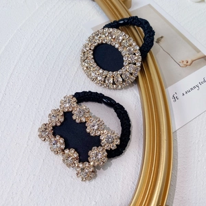Detail of luxury rhinestone hair tie featuring high-elastic black band and crystal accents