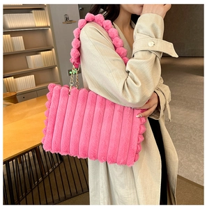 Detailed view of pink fuzzy tote with striped texture and plush ball gold chain strap