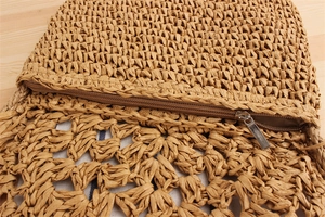 Woven straw shoulder bag detail shot, casual beach vacation commuter handbag for women.