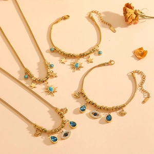 Detail view of gold stainless steel jewelry set with evil eye and star charms
