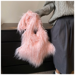 Model holding a trendy pink faux fur shoulder bag against a minimalist studio background