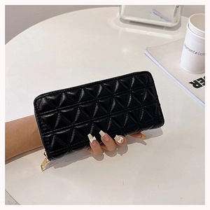 Close-up of black quilted long wallet with gold zipper and diamond stitching detail