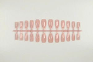 Macro detail of 24-piece nude pink almond-shaped false nails with jelly texture