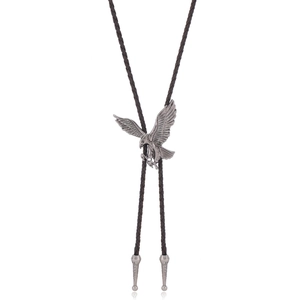 Detailed view of an antique silver eagle bolo tie pendant with brown braided leather cord