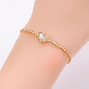 Detail of gold-plated tennis bracelet with pear-shaped stone and pave heart charm