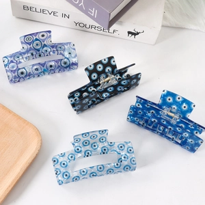 Blue evil eye print acetate hair claw clips for women set on minimalist display