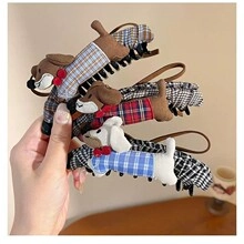 Detailed view of three plaid dog-shaped hair clips in brown, red, and blue patterns