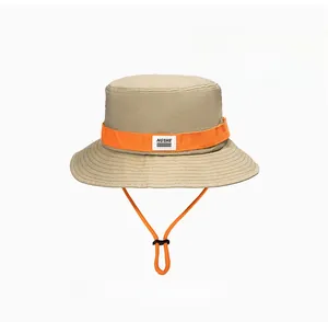 Close-up of khaki sun hat with orange strap, chin cord, and NGSHE logo detail