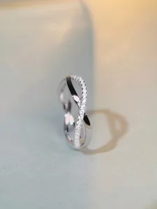 Close-up of S925 sterling silver crossover ring with pave-set shimmering zircon stones