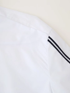 Detailed close-up of white sporty shirt shoulder with black and white striped webbing