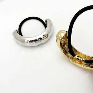 Detail of minimalist gold and silver hair rings with high-elastic bands and hammered texture