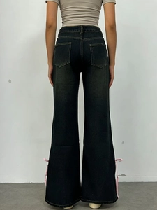 Jeans in denim lavaggio scuro a gamba larga con fiocchi rosa sul retro dell'orlo