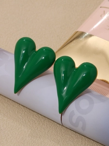 Macro shot of bright green heart studs with a glossy glazed finish on stainless steel