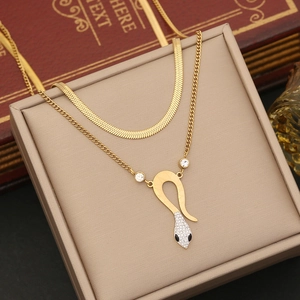 Close-up of double-layered gold chain necklace featuring a crystal snake pendant