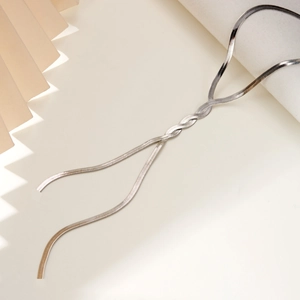 Detailed view of silver flat snake chain necklace with a modern twisted knot design