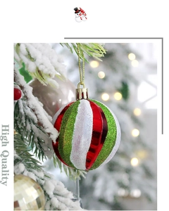 Detail von rot grün weiß gestreiften Weihnachtskugeln mit Glitzer auf schneebedecktem Baum