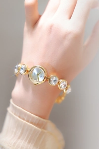 Détails de la montre pour femme or champagne avec cristaux ronds étincelants sur le bracelet