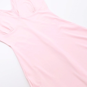 Detail view of pink ruffle hem and slit design on a slim-fit knit dress