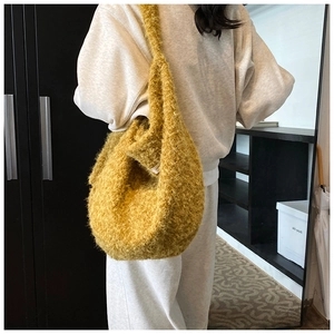 Detail of soft bright yellow fuzzy wool tote bag with plush texture and hobo silhouette