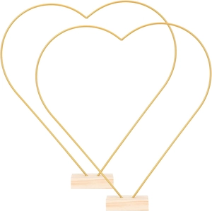 Detail of two golden heart-shaped metal hoops with rectangular wooden bases for DIY decor