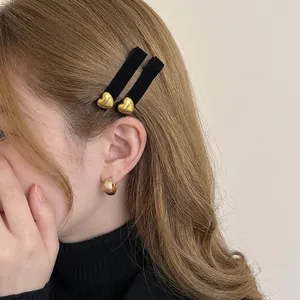 Fermagli per capelli in velluto nero con pendenti a cuore dorati e orecchini a cerchio abbinati