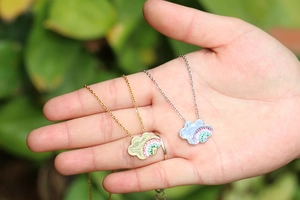 Handheld shot of gold and silver rainbow cloud pendant necklaces with colorful zircons