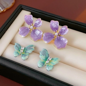 Détail de boucles d'oreilles vintage avec papillon, fleurs, perles et strass