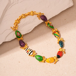 Detailed close-up of golden enamel Easter egg charms with bowknots on a bracelet