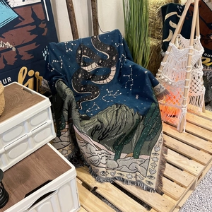 Detailed texture of bohemian woven camping blanket with snake and star patterns and tassels