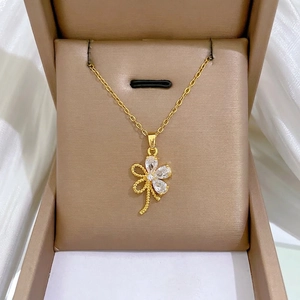 Elegante goldene Titankette mit hohlem Blumenanhänger und Zirkonia Steinen in einer Geschenkbox