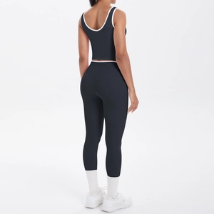 Back view of high-waist black yoga leggings and cropped tank top with white contrast piping