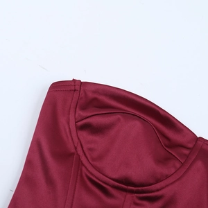 Detail of burgundy satin corset top featuring off-shoulder V-neckline and boning structure
